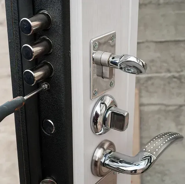 Una persona está arreglando una puerta con un destornillador.