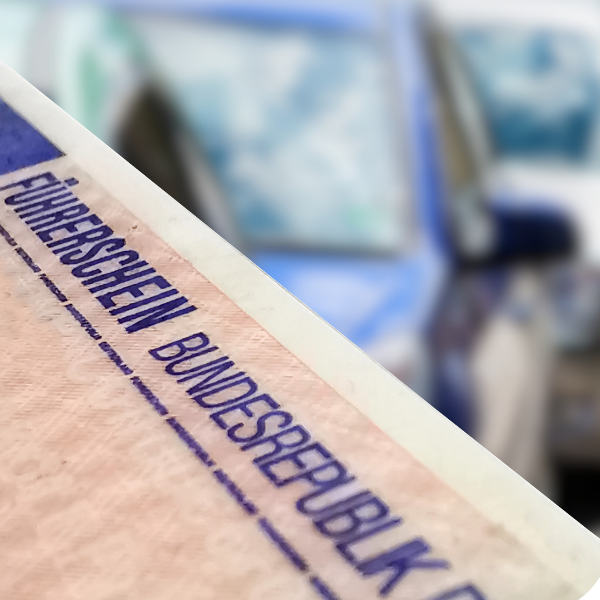Ein blaues Schild mit der Aufschrift „FÜHRERSCHEIN BUNDESREPUBLIK“, im Hintergrund verschwommene Autos.