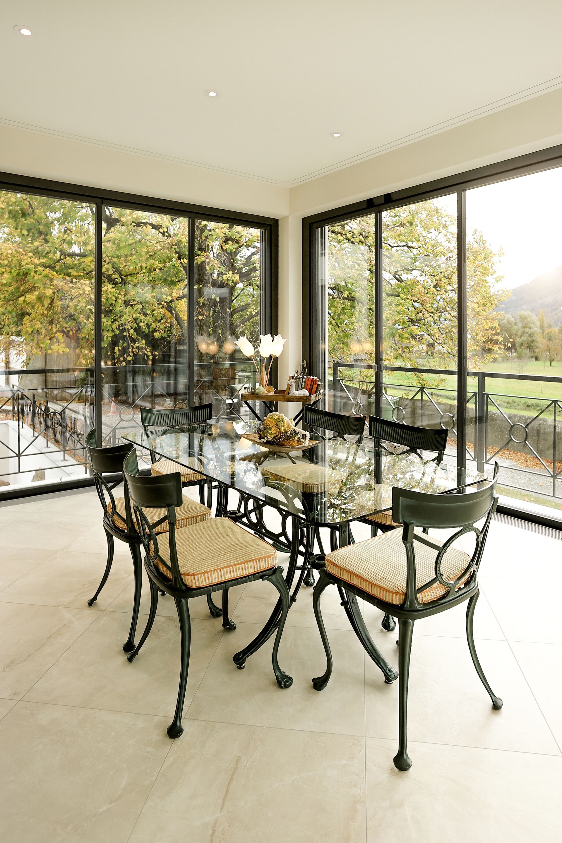Eine Frau mit blauen Handschuhen reinigt einen Holztisch mit einem Tuch und einer Sprühflasche. Ladinas Reinigungen GmbH