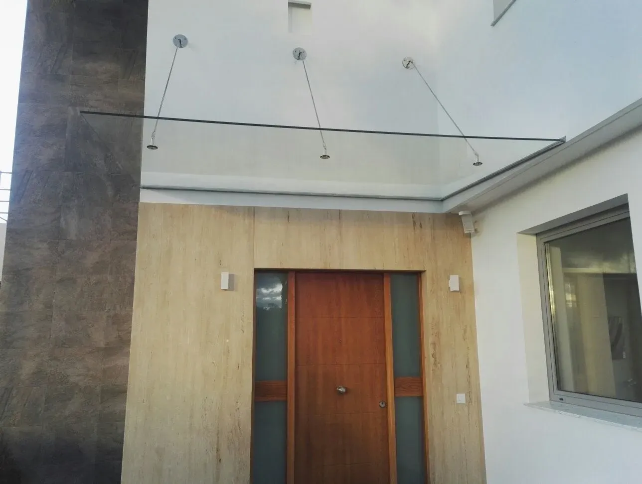 Vista interior a través de un gran ventanal de cristal de un edificio residencial de varias plantas.