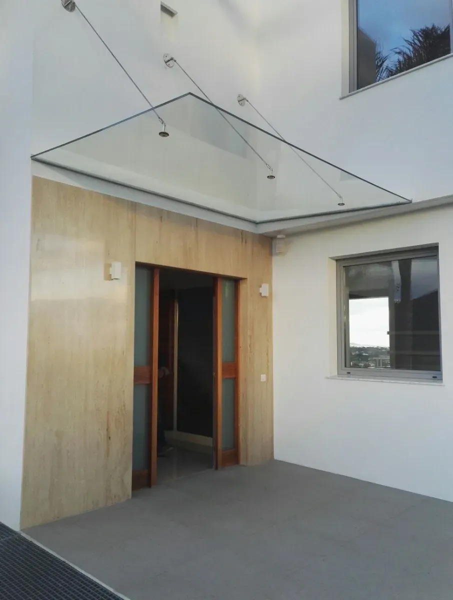 Entrada moderna con marquesina de cristal