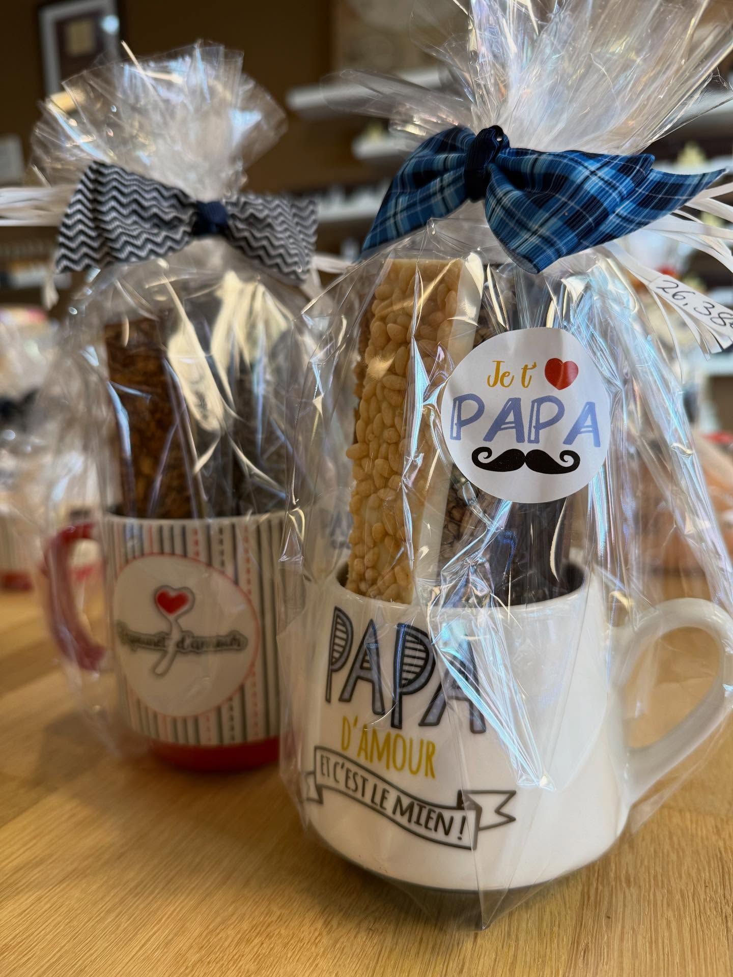 Deux coffrets cadeaux pour la fête des Pères, dans des mugs, emballés sous cellophane avec des nœuds. L'un d'eux est orné de l'inscription Je t'aime Papa.