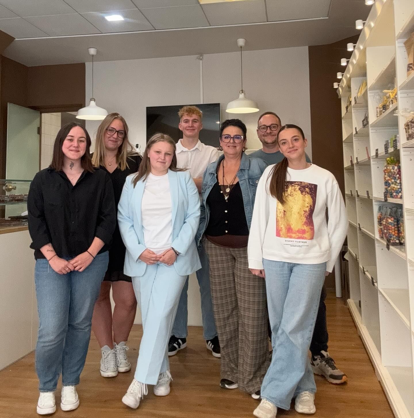 Un groupe de huit personnes debout dans une chocolaterie.