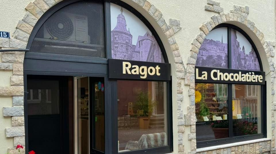 Extérieur de la chocolaterie Ragot La Chocolatière avec des fenêtres cintrées et une façade en pierre.