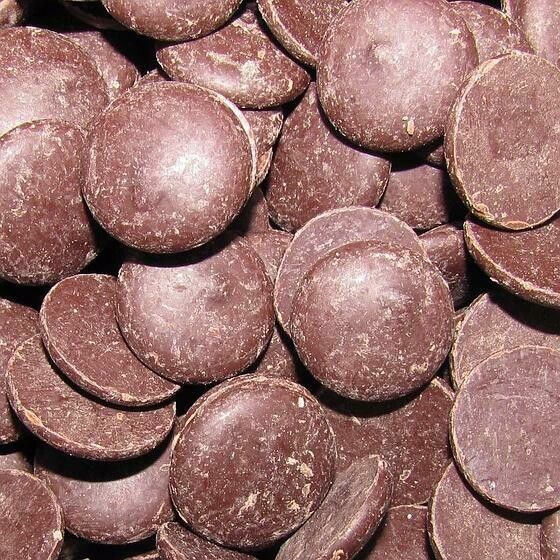 Pastilles de chocolat brun foncé, empilées les unes sur les autres.