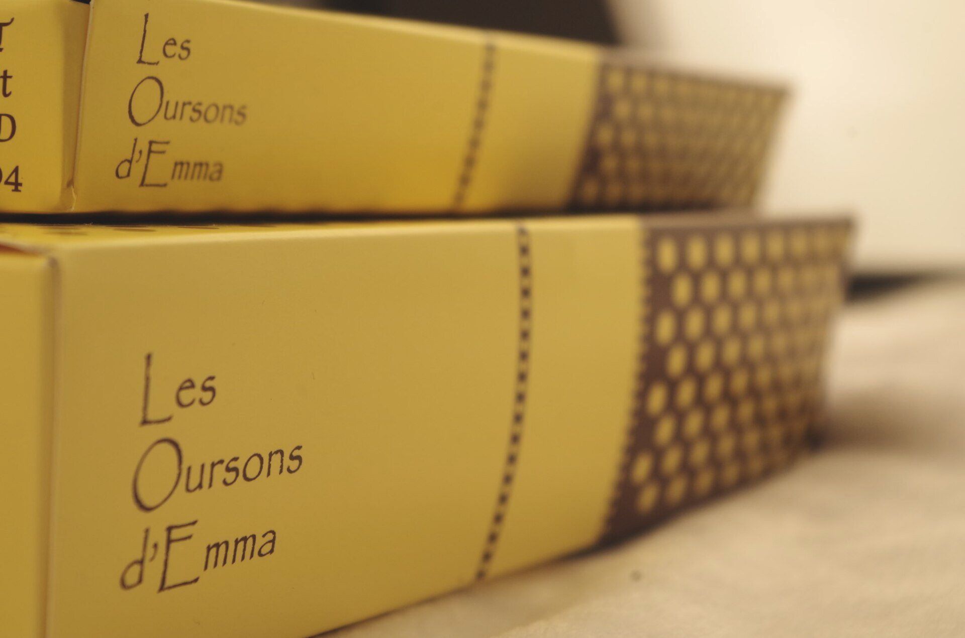Boîtes jaunes Les Oursons d'Emma imprimées en texte noir, avec motif pointillé marron sur le côté.