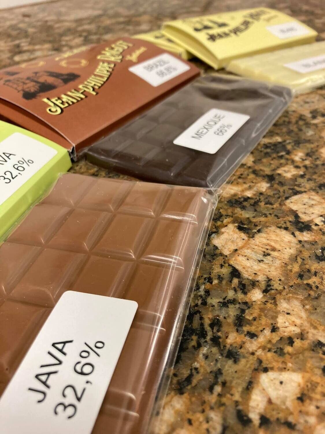 Gros plan de plusieurs barres de chocolat, chacune avec un pourcentage et une étiquette d'origine différents.