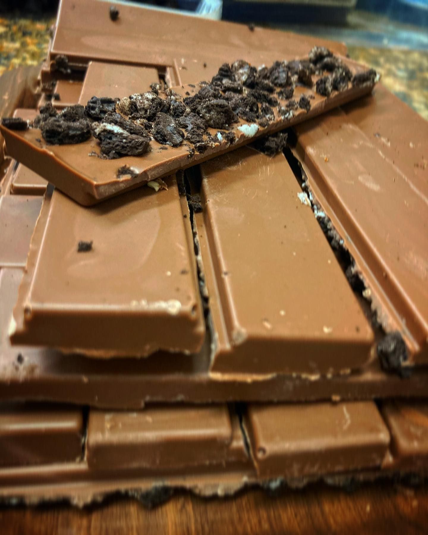 Barres de chocolat empilées, certaines avec des biscuits écrasés sur le dessus.