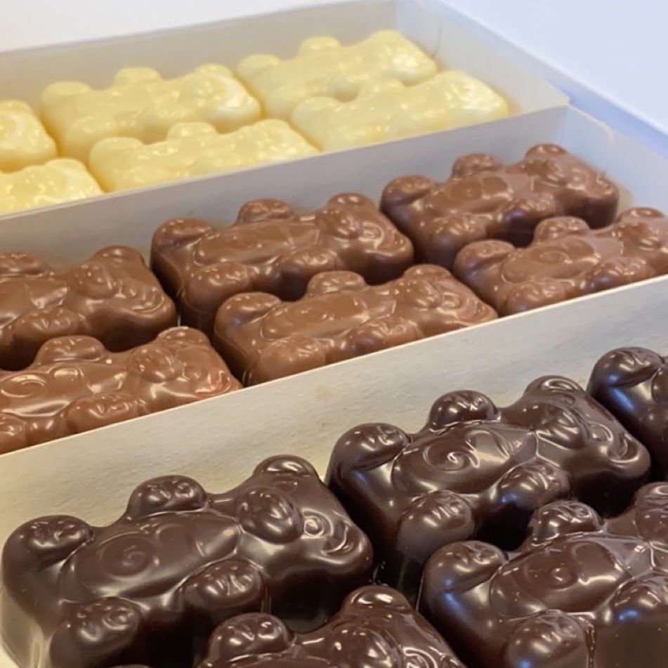 Boîte de bonbons en forme d'oursons en gélatine au chocolat blanc, au lait et noir.