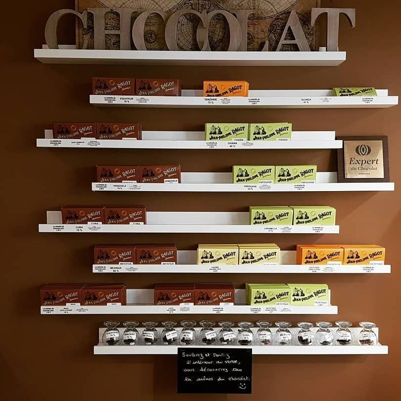 Étagères présentant des barres et des pots de chocolat dans un magasin avec une enseigne CHOCOLAT.