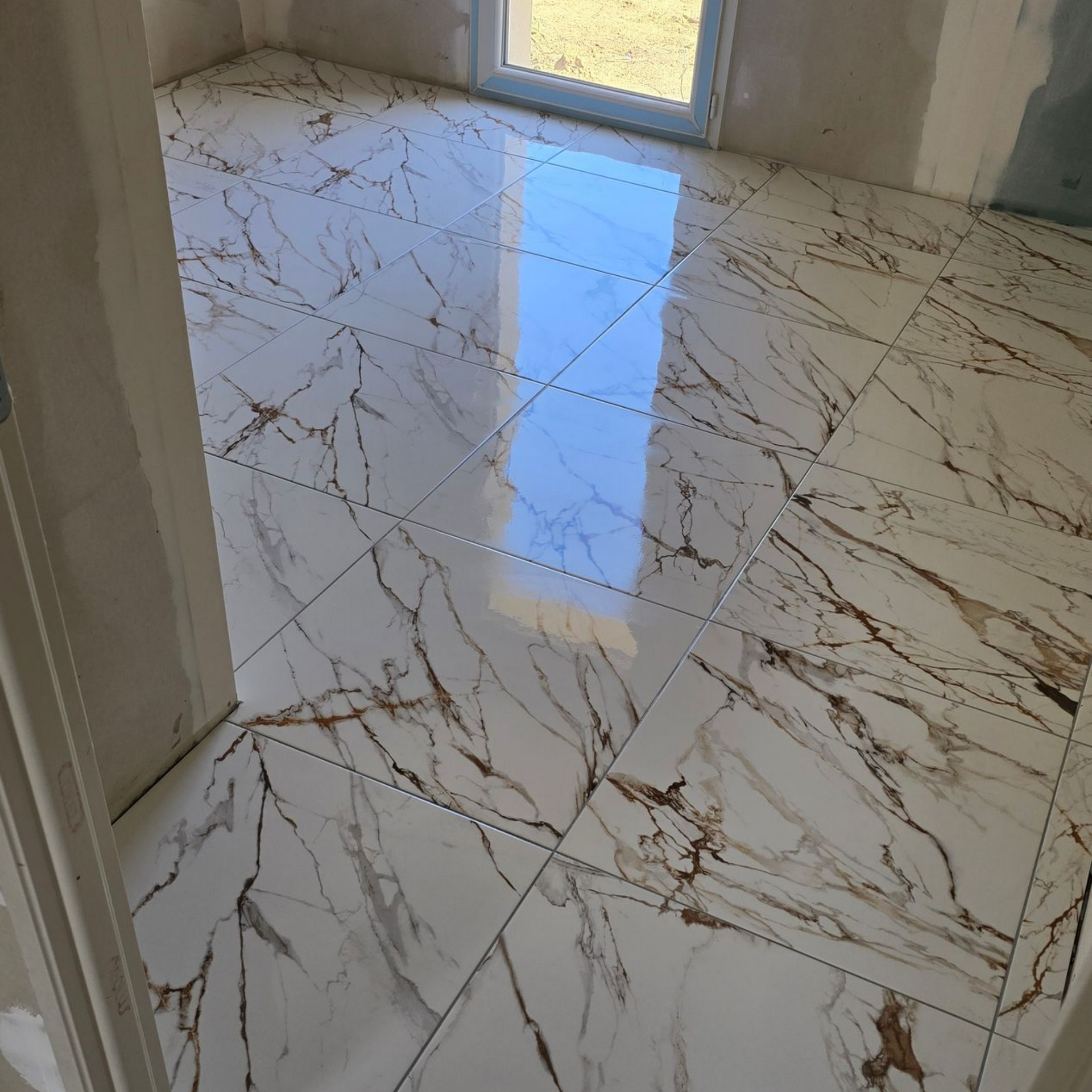 Pièce lumineuse avec un sol carrelé en marbre blanc brillant.