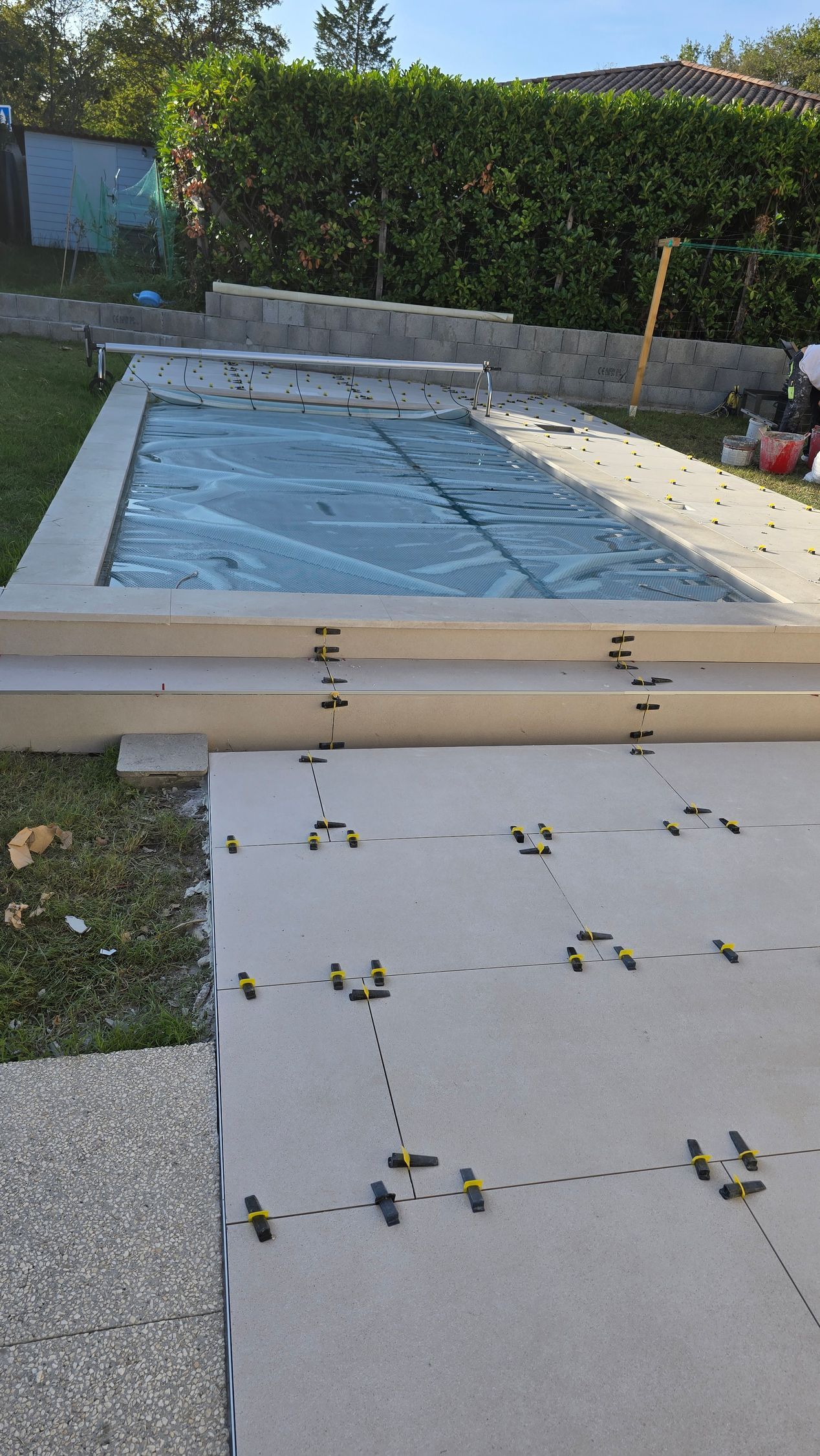 Terrasse arrière avec piscine rectangulaire couverte.