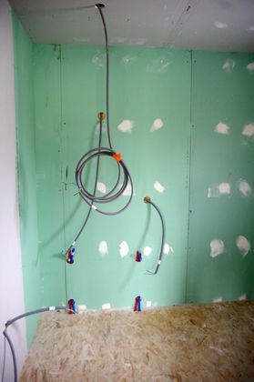 Mur avec câblage et prises électriques apparents au-dessus d'un établi en construction