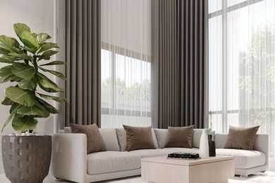 Sala de estar moderna con sofá seccional beige, mesa de centro, planta grande y ventanales del suelo al techo.