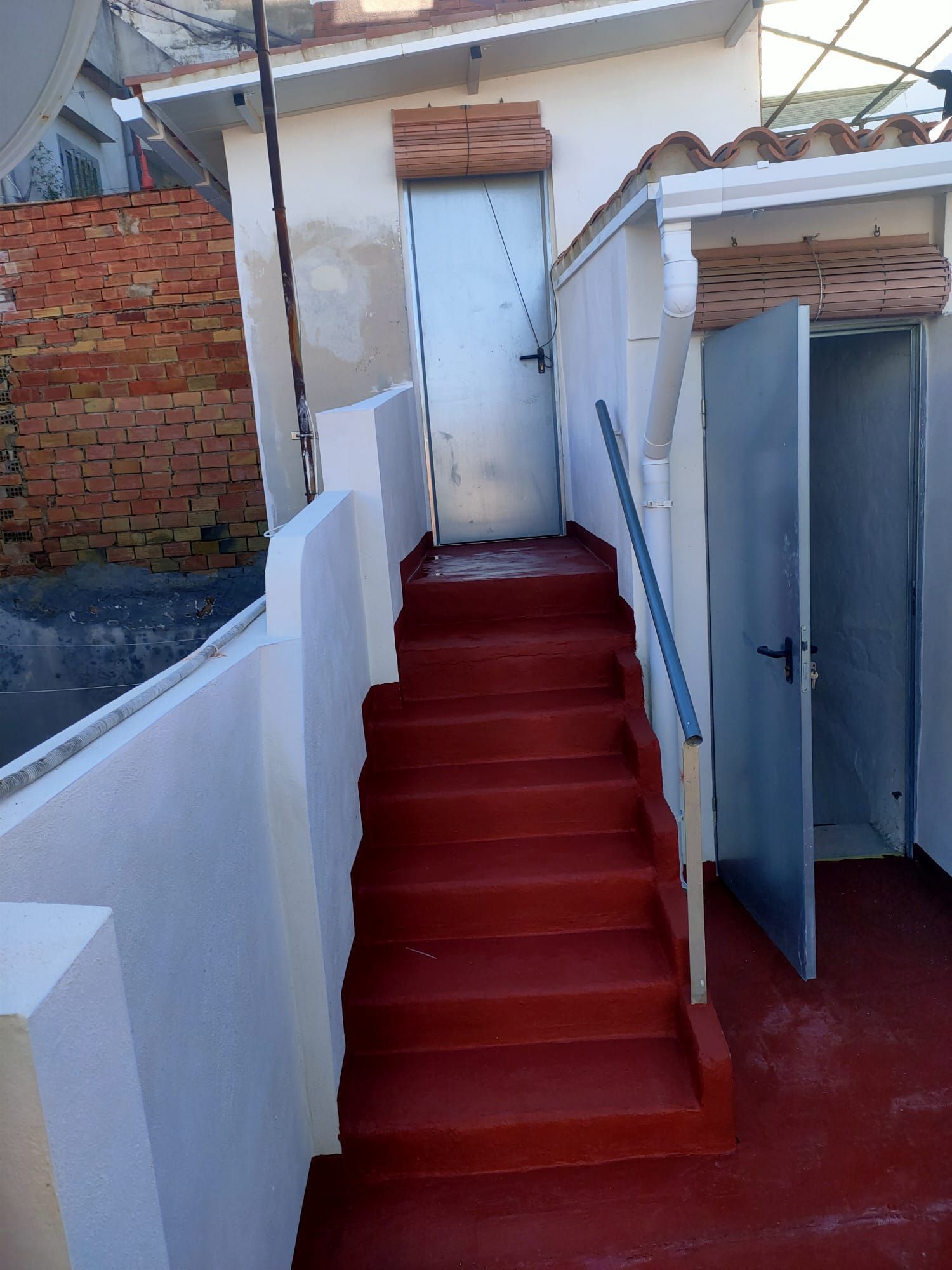 Un conjunto de escaleras rojas que conducen a un edificio blanco.