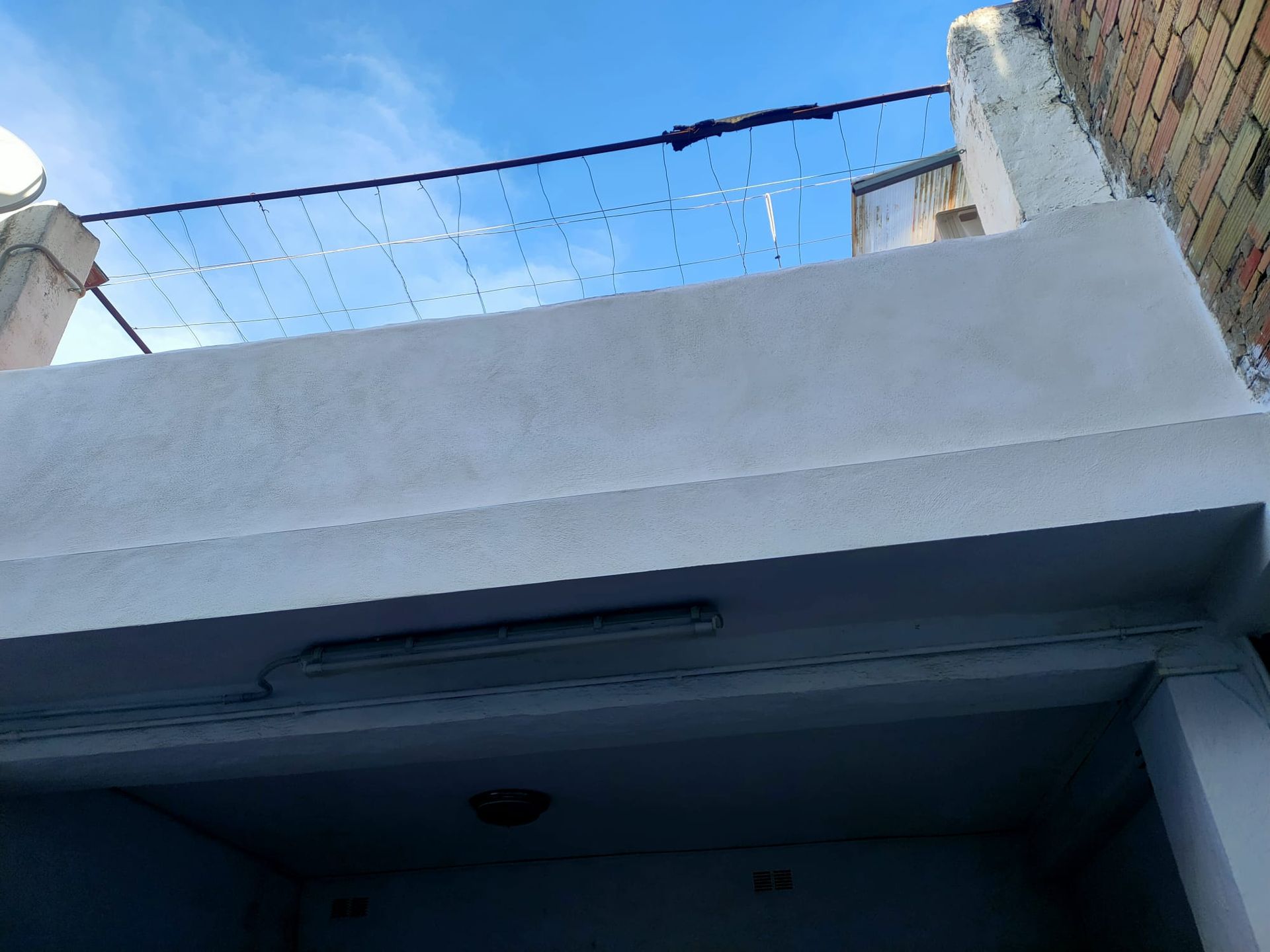 Un edificio con escaleras y una antena parabólica encima.