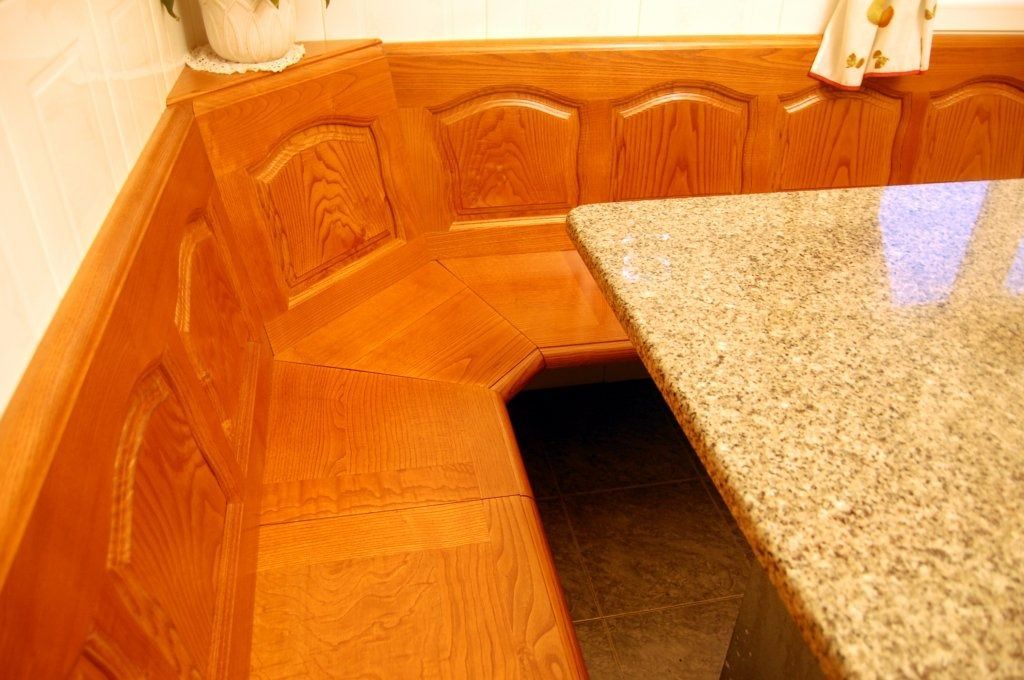 Una cocina con banco de madera y encimera de granito.