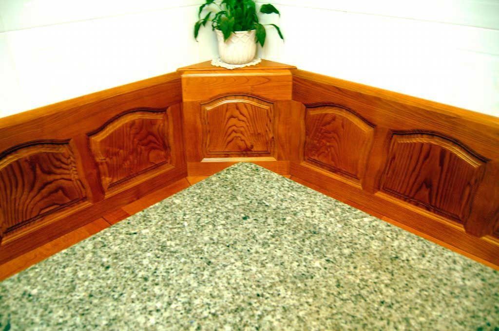 Un rincón de una habitación con paneles de madera y una planta en una maceta.