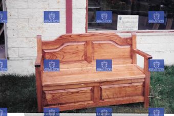 Un banco de madera está sentado frente a un edificio de ladrillos.