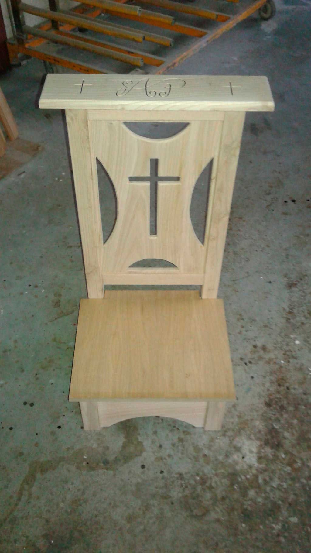 Una silla de madera con una cruz en el respaldo está colocada sobre un suelo de hormigón.