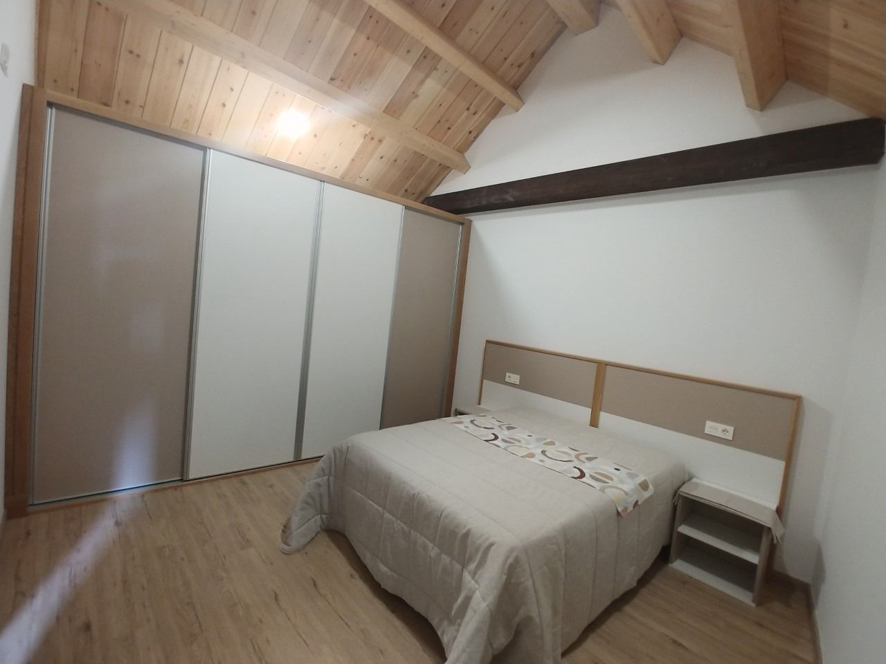 Un dormitorio con una cama grande y puertas correderas.