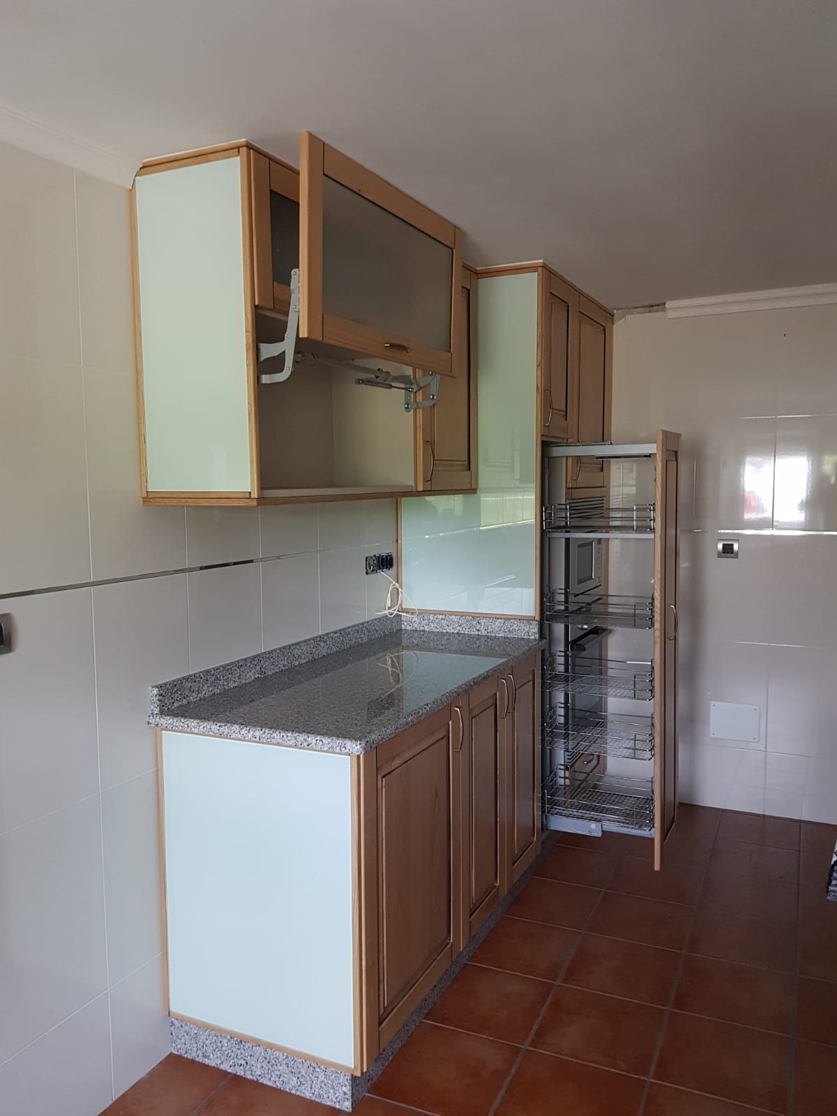 Una cocina con gabinetes de madera y refrigerador.
