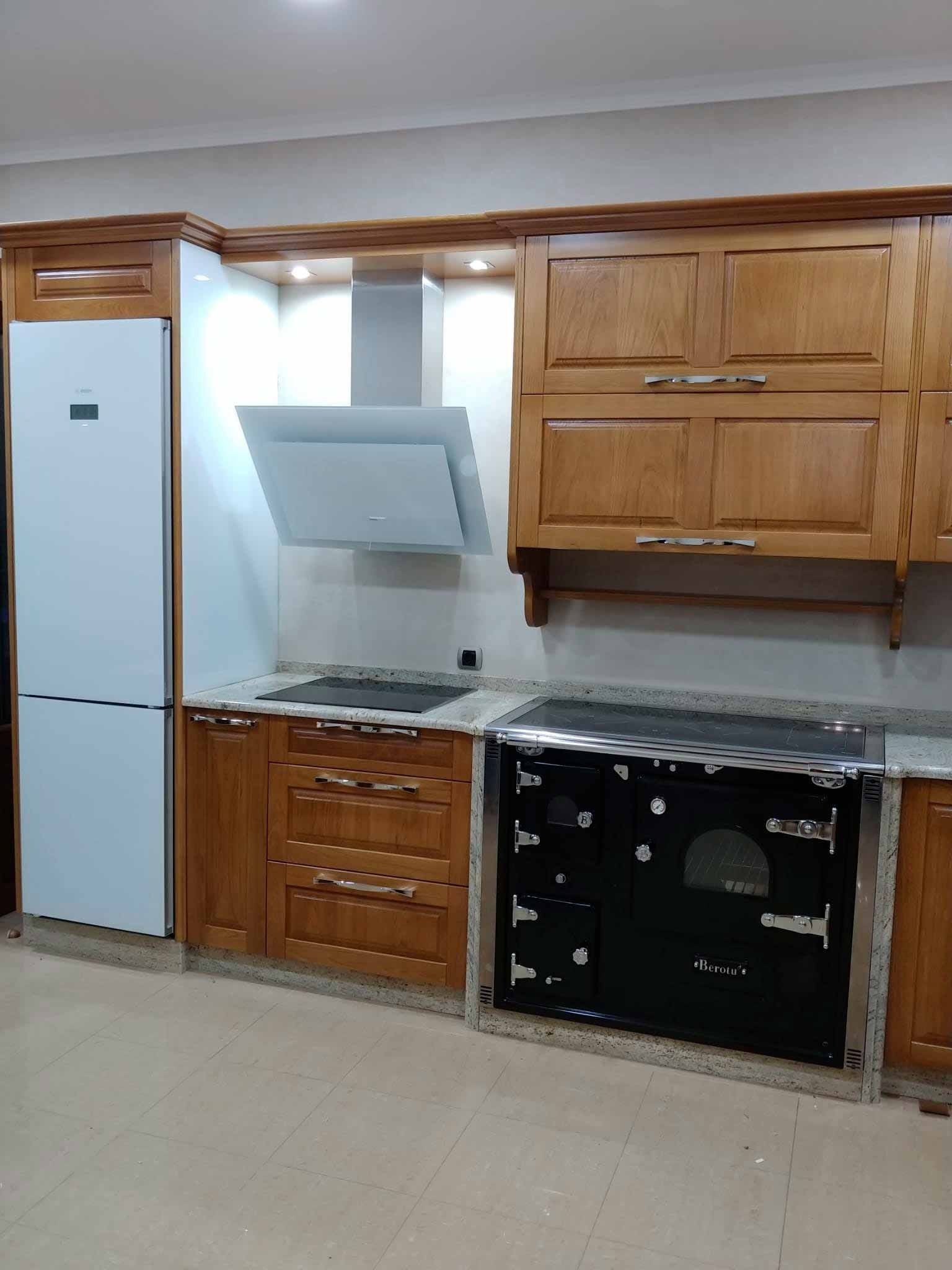 Una cocina con gabinetes de madera y una estufa negra.