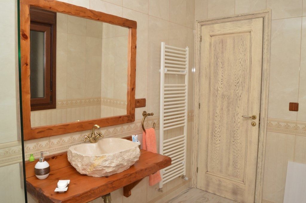 Un baño con lavabo, espejo y toallero.