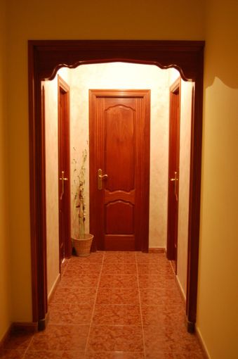 Un pasillo con una puerta de madera en el medio.