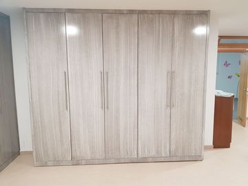Un gran armario está en una habitación al lado de una puerta.