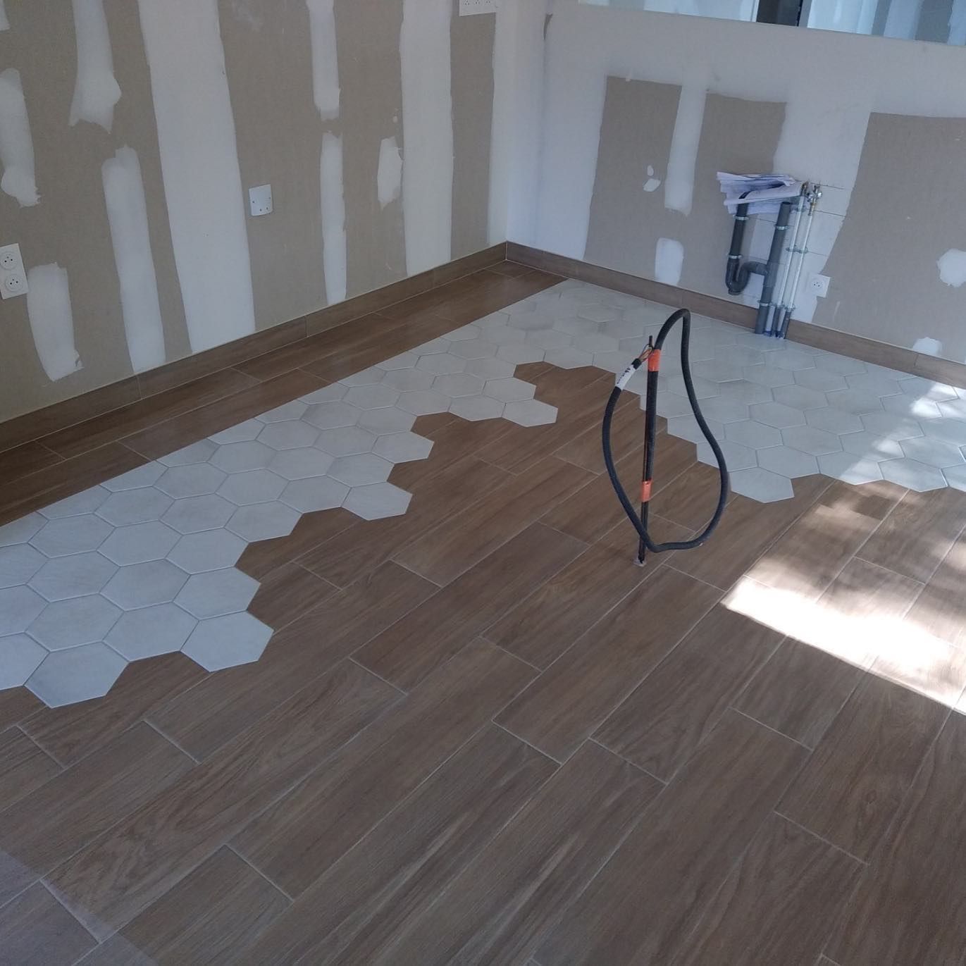 Sol d'un pièce imitation parquet avec portion de dalles héxagonales blanches