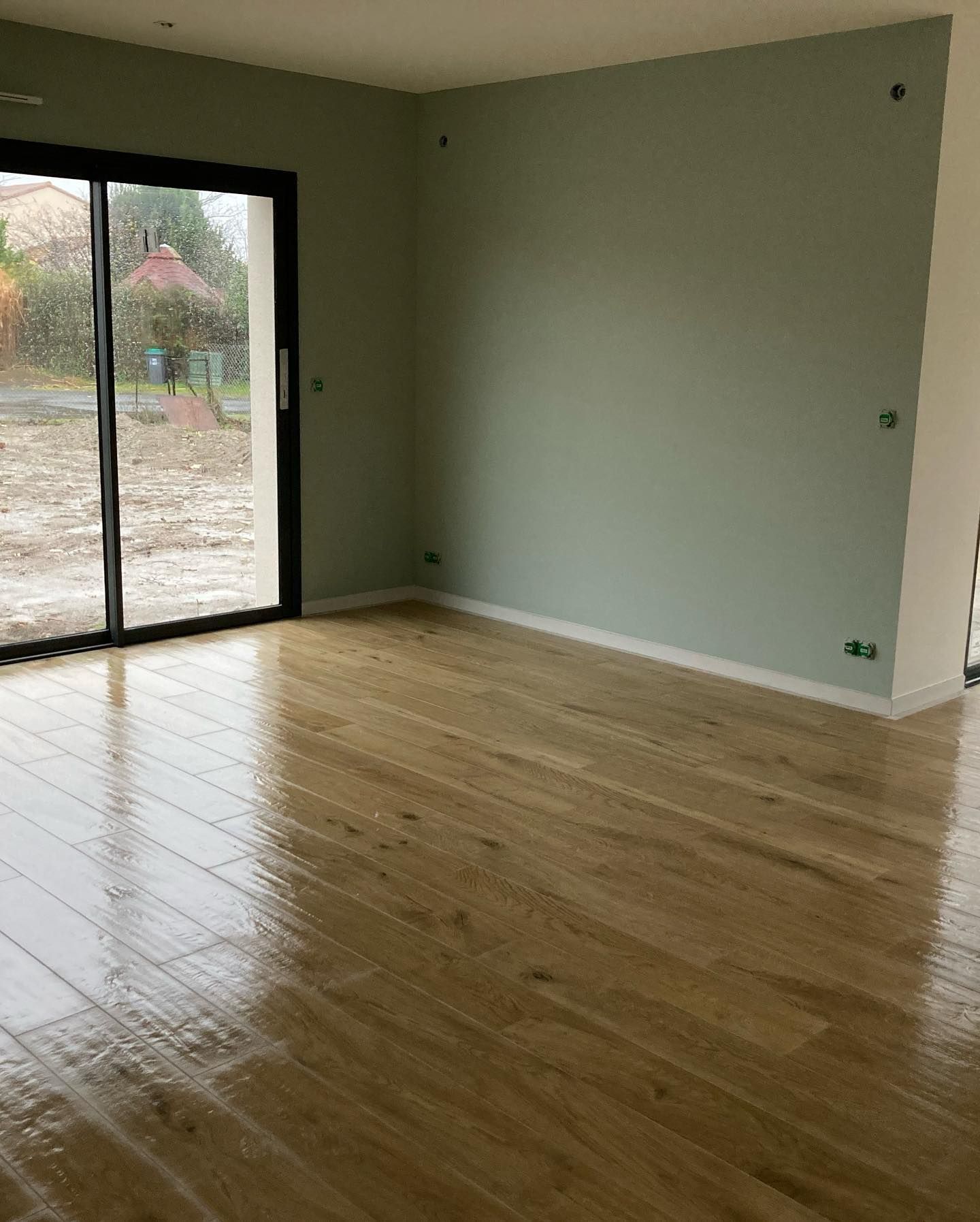 Sol imitation parquet dans une pièce avec porte fenêtre