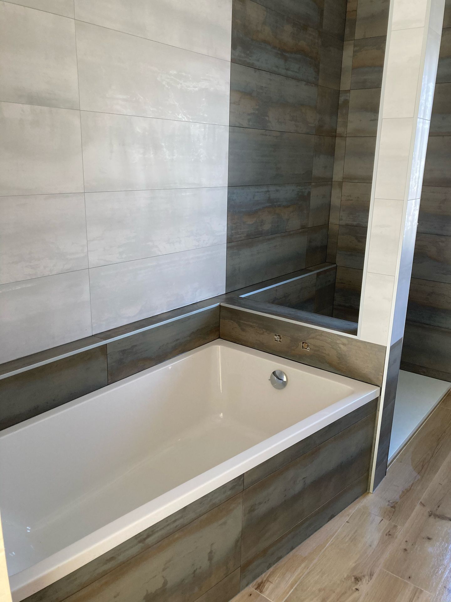 Baignoire d'une salle de bains avec carrelage blanc et marron foncé