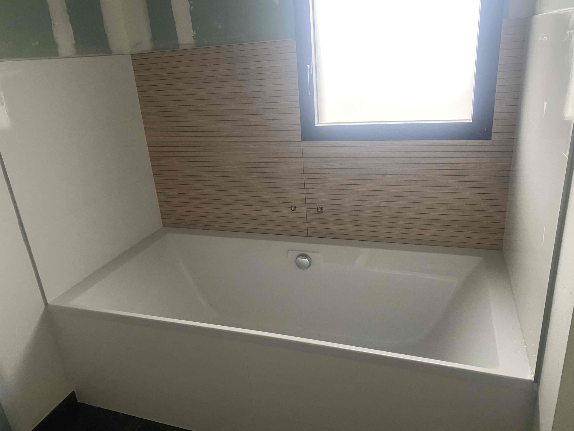 Baignoire blanche contre un mur avec bardage en bois