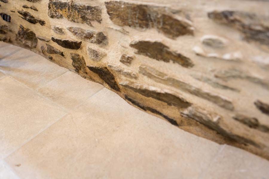 Carrelage collé à un mur en pierre