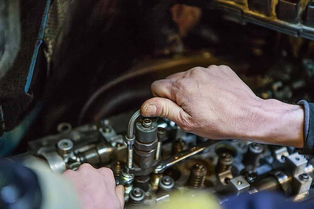 vue de près d'un moteur et d'une main de mécanicien