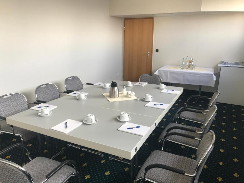 Konferenzraum mit großem Tisch, Stühlen und Erfrischungen für ein Meeting.