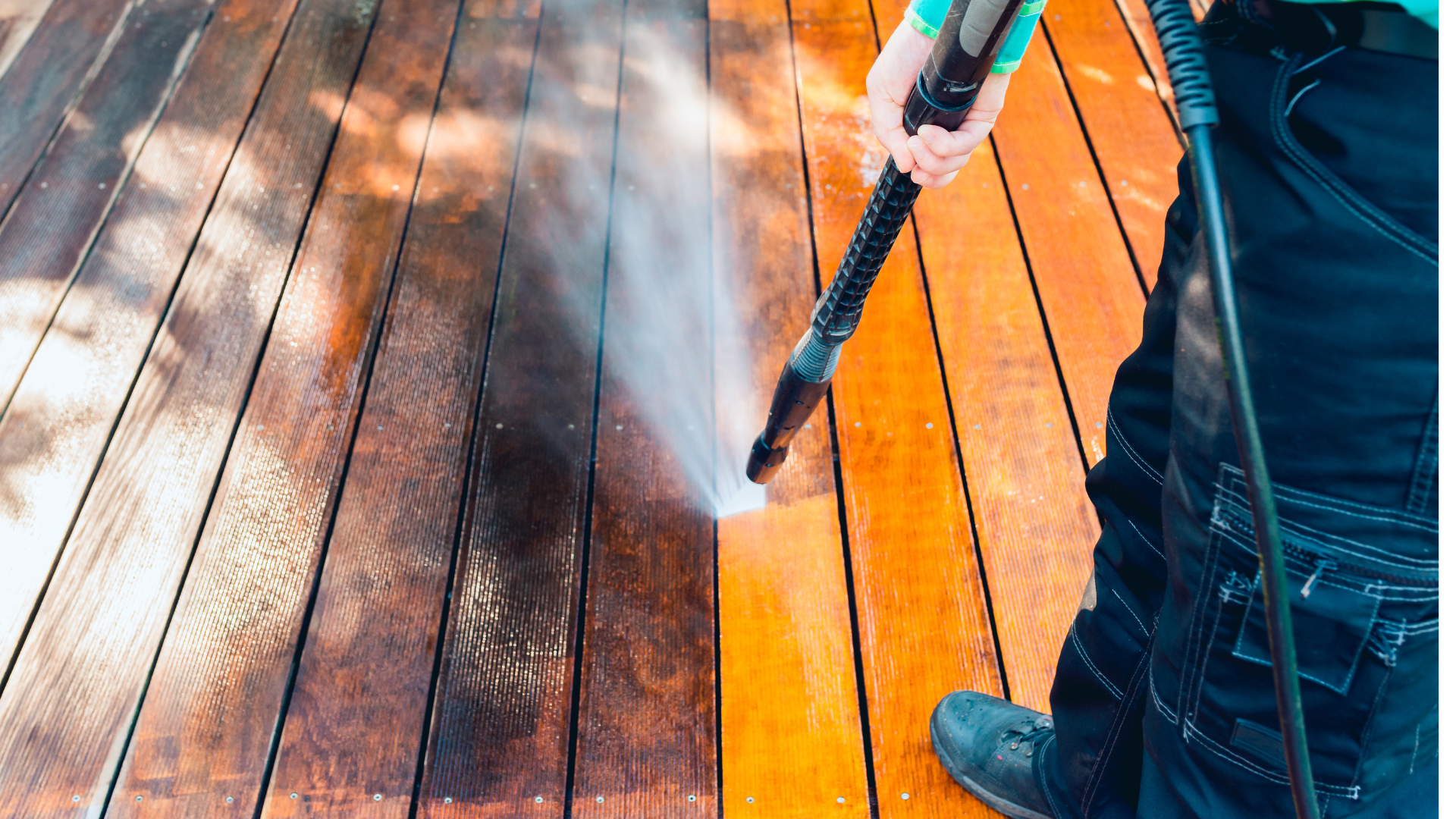 Une personne nettoie à haute pression un toit de tuiles rouges ; elle pulvérise de l'eau.