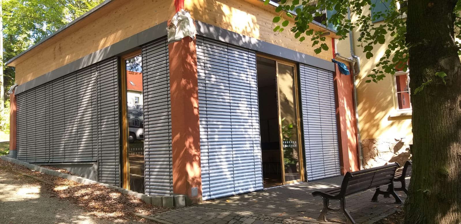 Ein Gebäude mit vielen Fenstern und einem Teich davor.