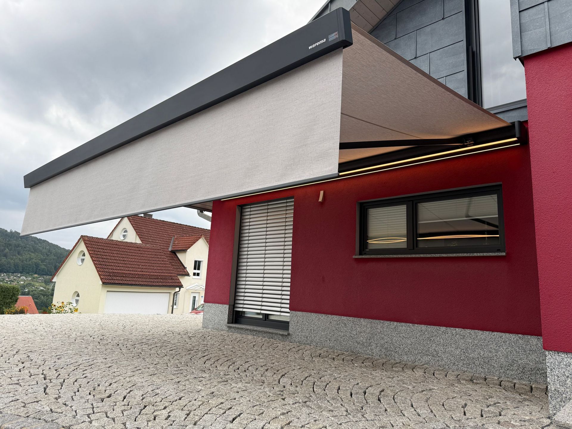 Markiese ausgefahren an einem roten Haus