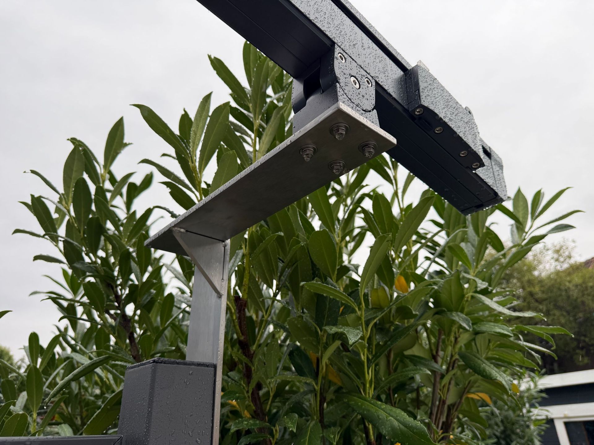 schwarzes Metallgestell vor einem grünen Busch