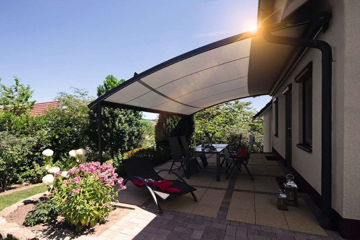 Eine Pergola mit weißem Dach und weißen Jalousien.