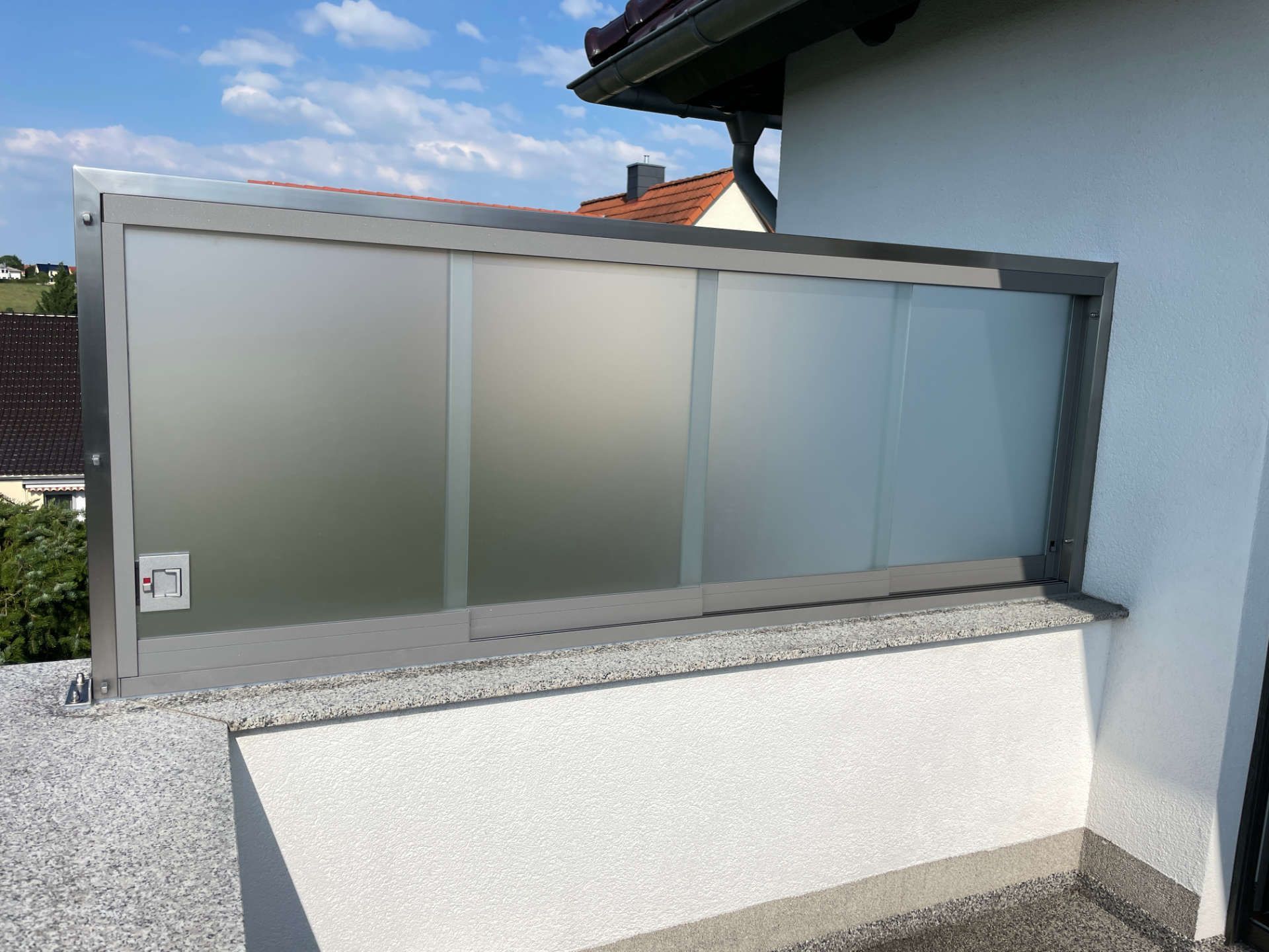 Eine weiße Wand mit einer Glasschiebetür darauf.