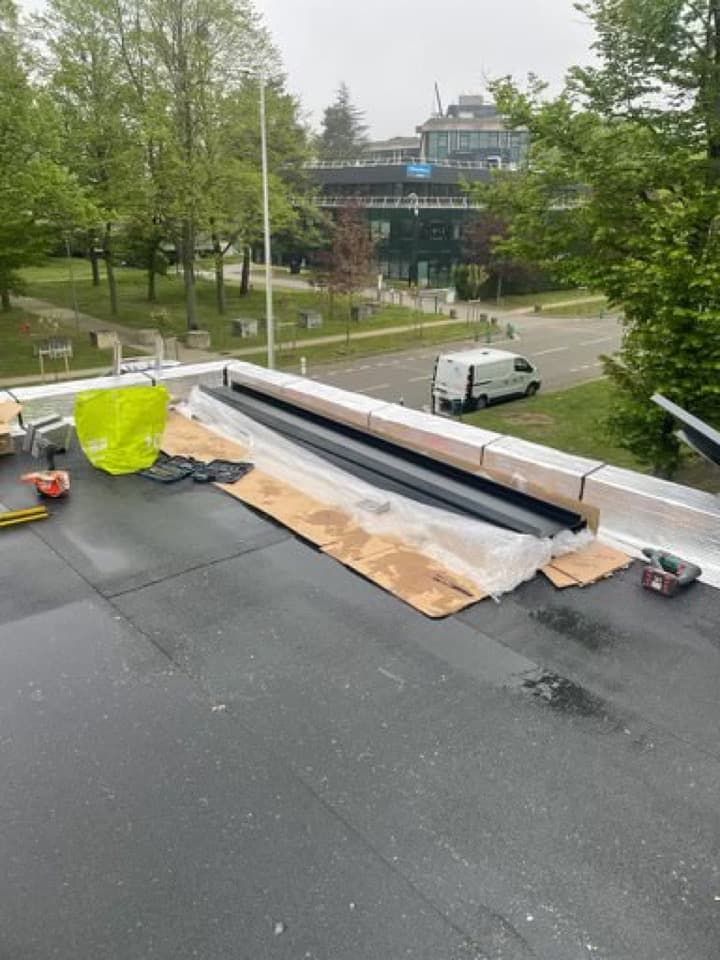 Construction d'un toit avec une surface en goudron noir.