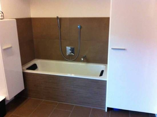 Une salle de bain avec une baignoire et un pommeau de douche