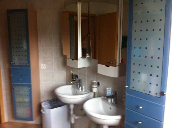 Une salle de bain avec deux lavabos et une poubelle