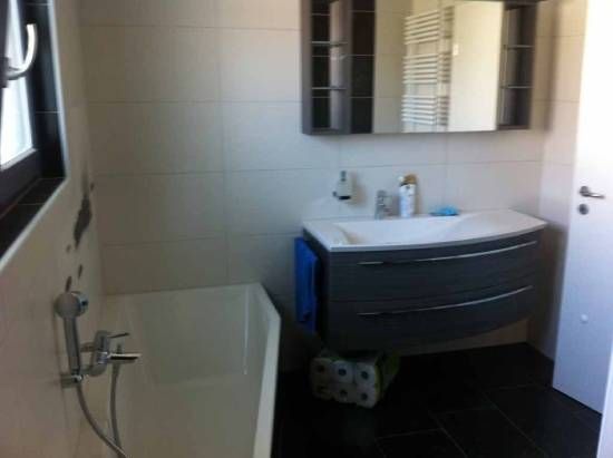 Une salle de bain avec lavabo, baignoire et miroir.