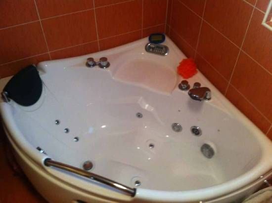 Une baignoire blanche dans une salle de bain avec du carrelage rouge