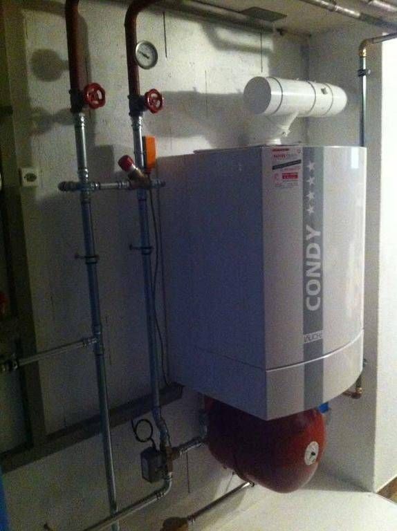 Une chaudière à condy blanche est accrochée au mur