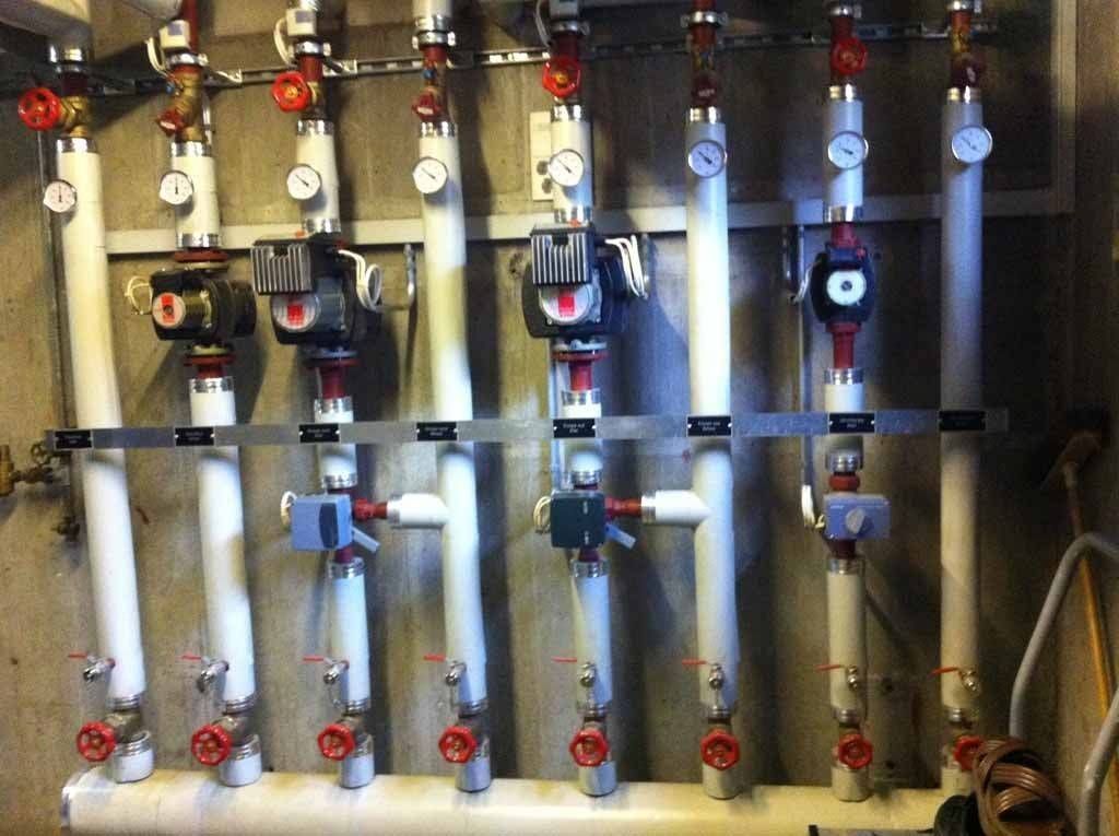Une rangée de tuyaux blancs avec des valves rouges dessus